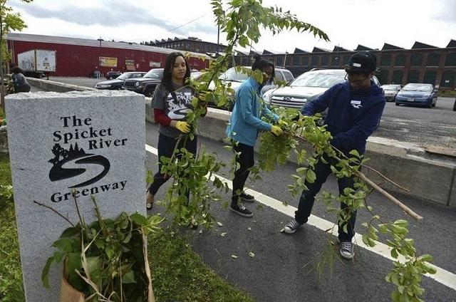 People doing landscaping at the Spicket River Greenway in Lawrence, Massachusetts