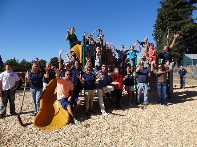 Coeur d'Alene Association of REALTORS® staff gathered around a kids playground area at Rathdrum Parks and Recreation