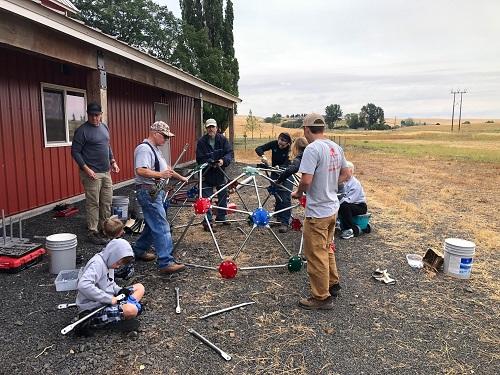 Volunteers assembling climbing dome equipment at the Viola Community Center