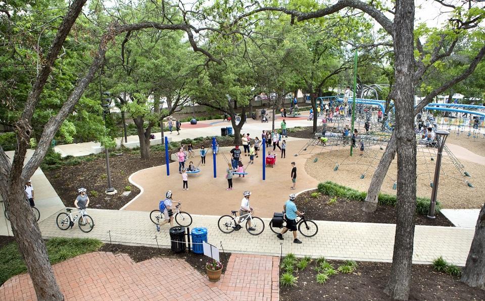 People riding bicycles and kids playing at the Yanaguana Garden, downtown San Antonio