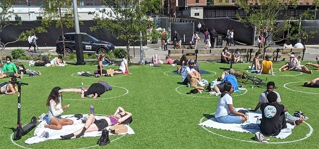 People sitting on the grass at Domino Park, NY