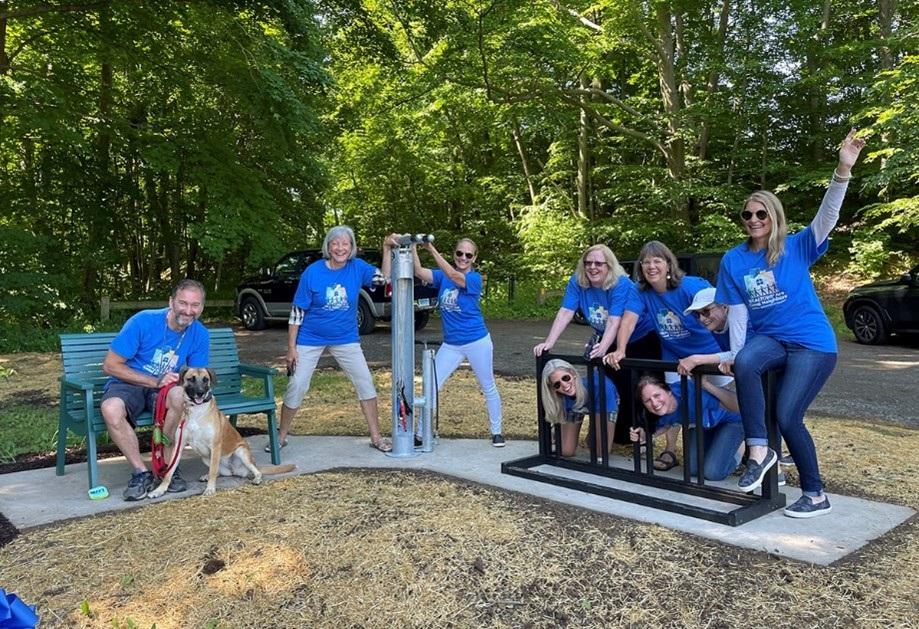 Members of the Greater Hartford Realtors® photo op next to bench, bike trail, and bike filling station at Dividend Pond Trail