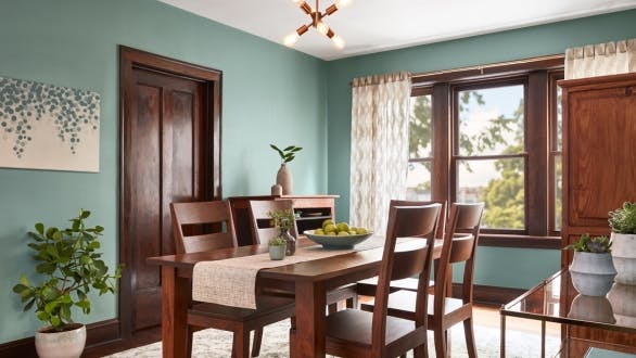 green dining room with wood trim