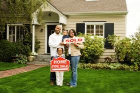 Family with sold home sign