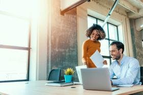 Two business people consulting on project in modern office