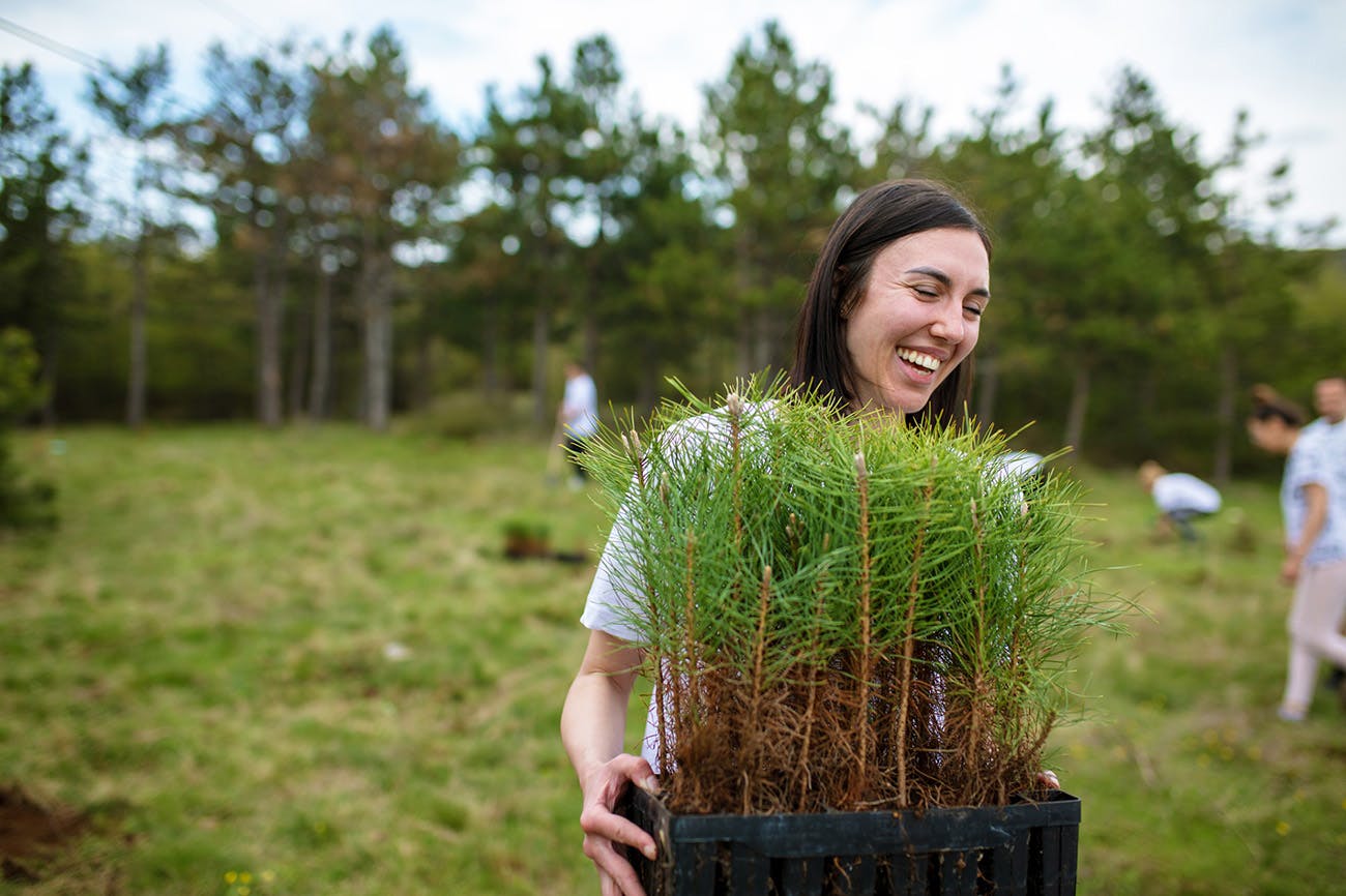 Woman smiling holding plants