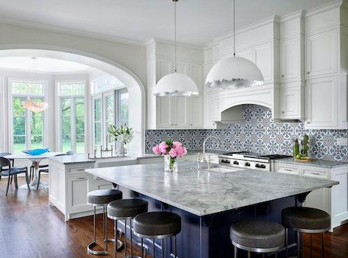 White Kitchen With Blue Backsplash and Marbled Island