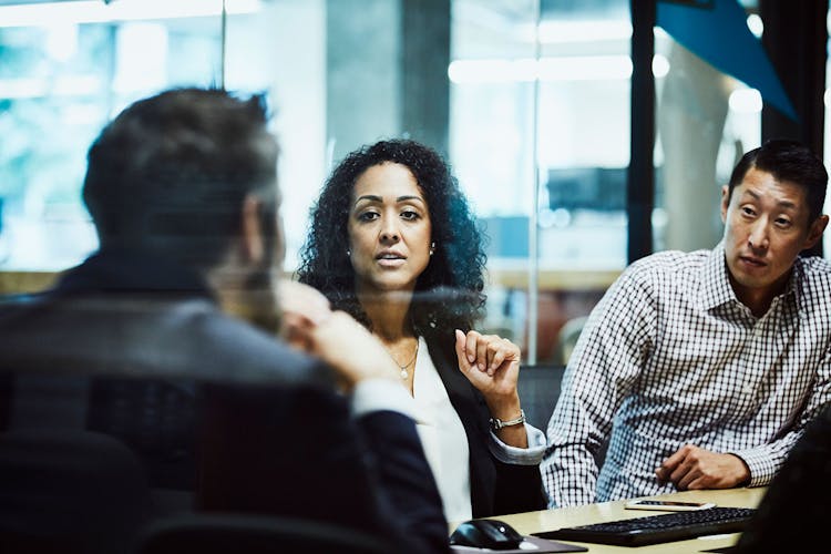 Businesswoman leading meeting with clients in office conference room