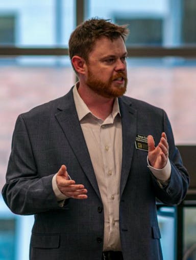 Dave Conroy speaking in front of a window