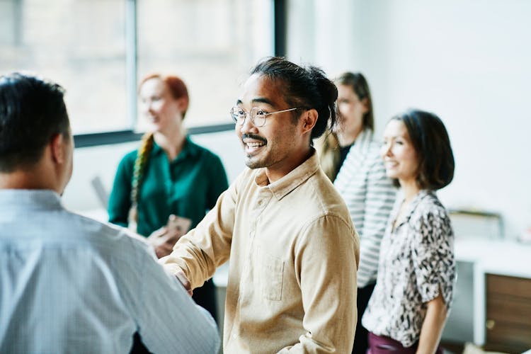 Businessman shaking hands with colleagues in a bright office