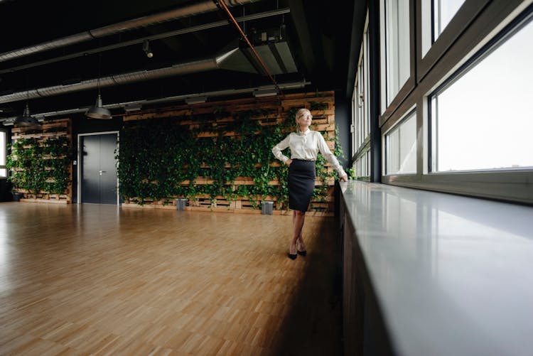 Businesswoman in green office looking out of window 