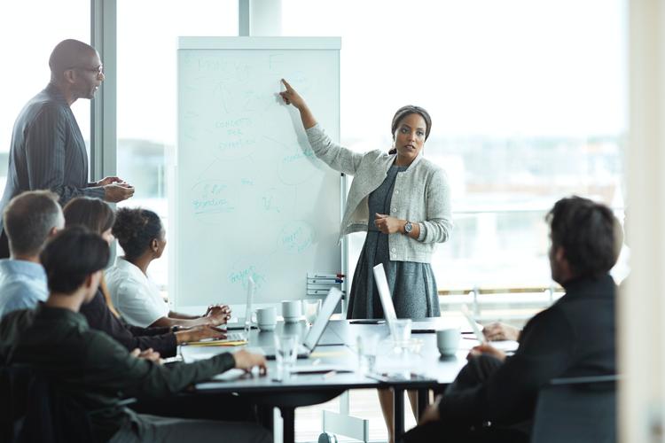 Businesswoman leading presentation in big boardroom