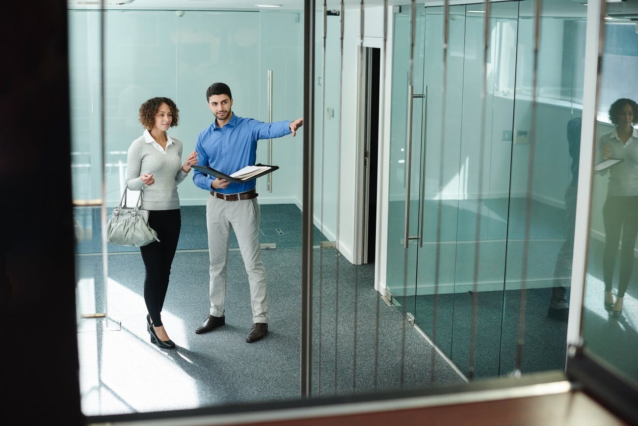 business woman viewing empty office space with real estate agent