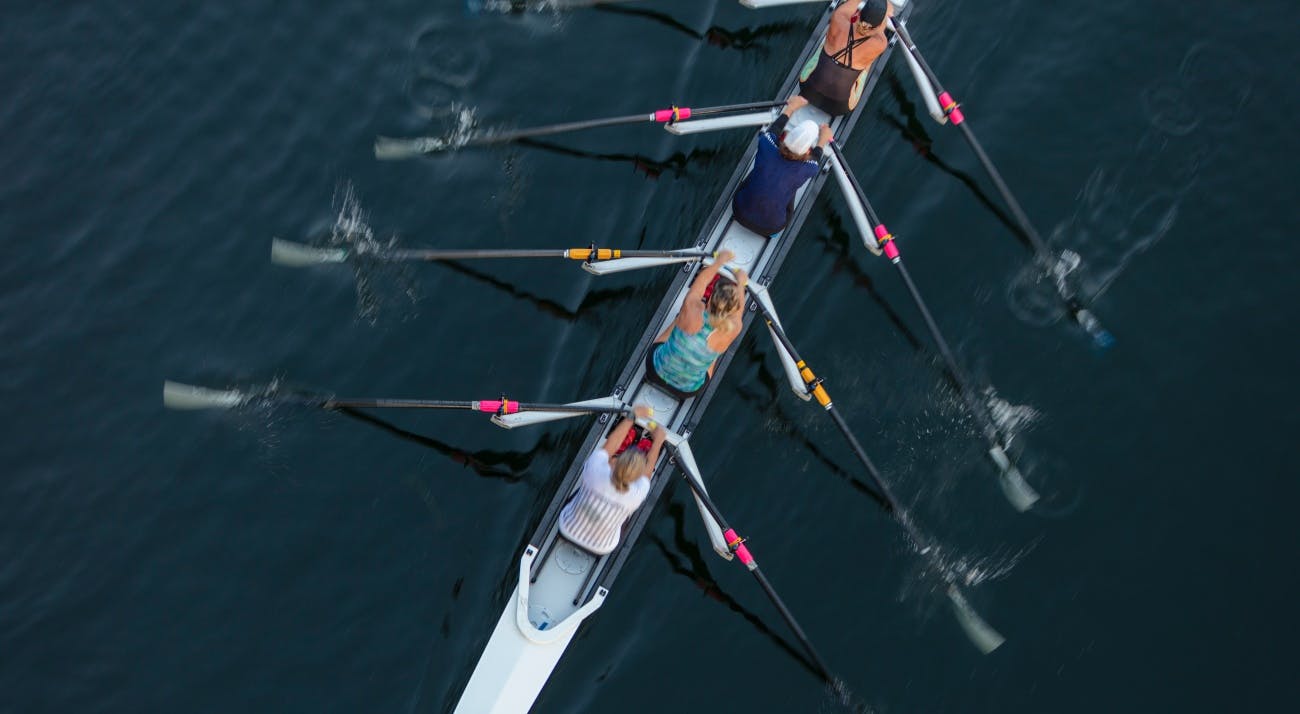 Overhead view of three people rowing a boat