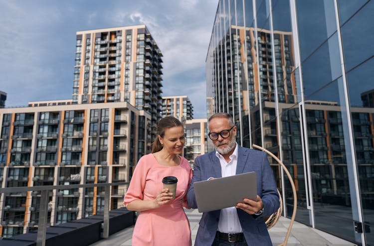 two colleagues collaborating in urban area with laptop