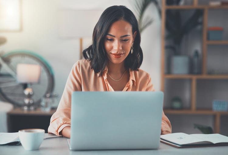 Woman in Business Attire Working in a Home Office on a Laptop