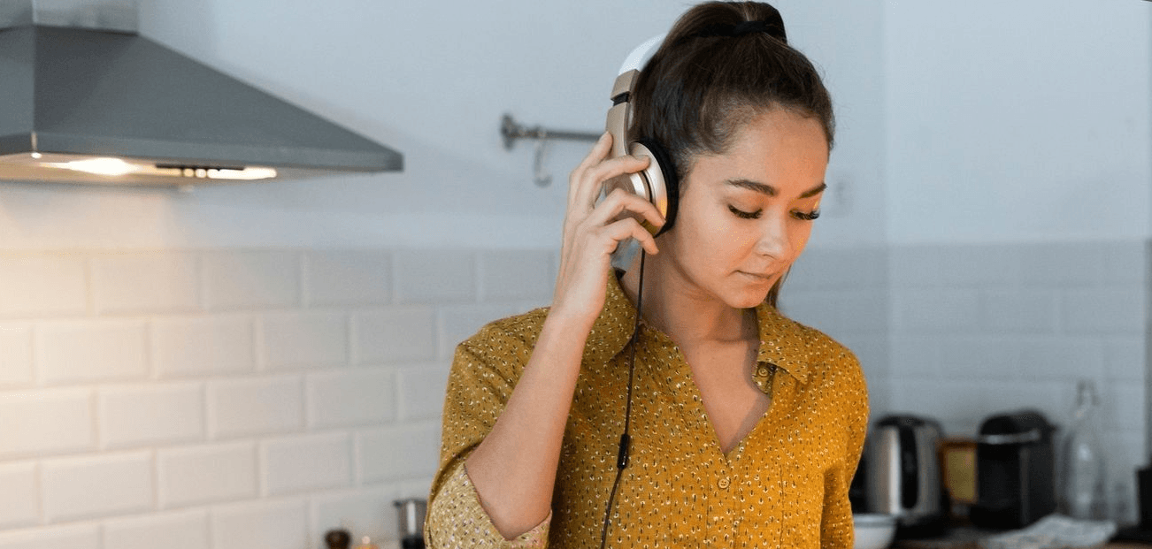 young woman listening to headphones in a house