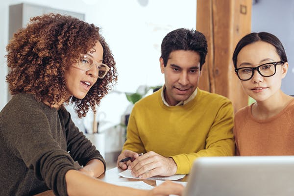 Couple with agent showing them something on laptop