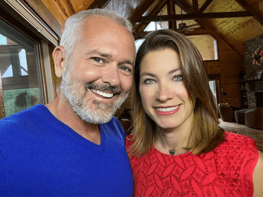 woman with light brown hair standing next to man with gray hair and short beard, both smiling