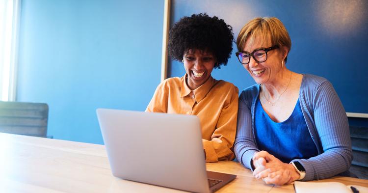 Two businesswomen with laptop survey