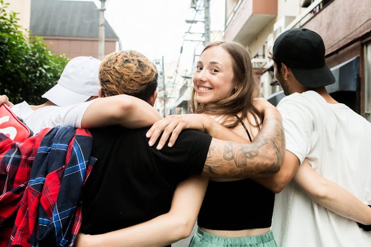 Woman Backpacker Looking Over Shoulder Walking With Friends