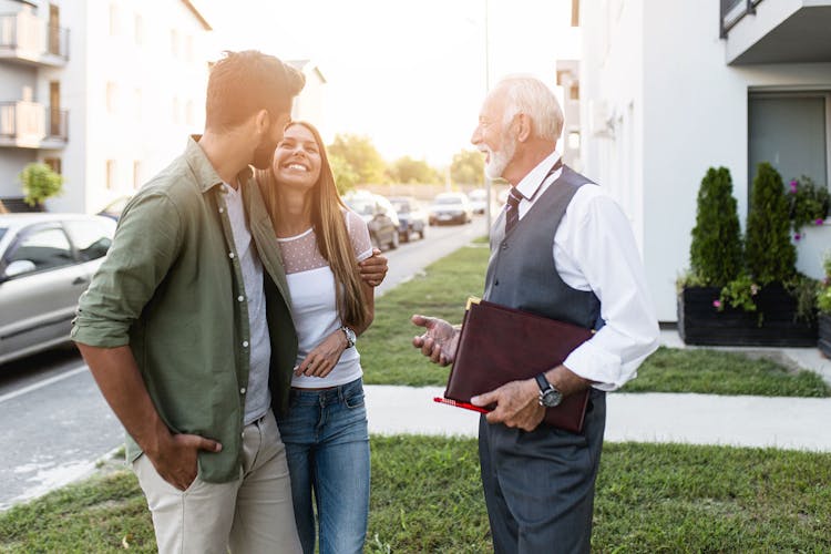 Young Couple Talking w Real Estate Agent Buying New House