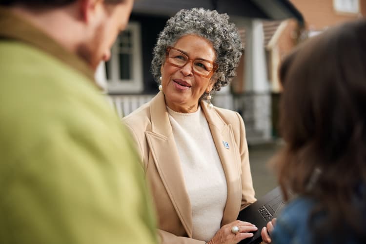 REALTOR® Agent with Couple Outside Home Viewing