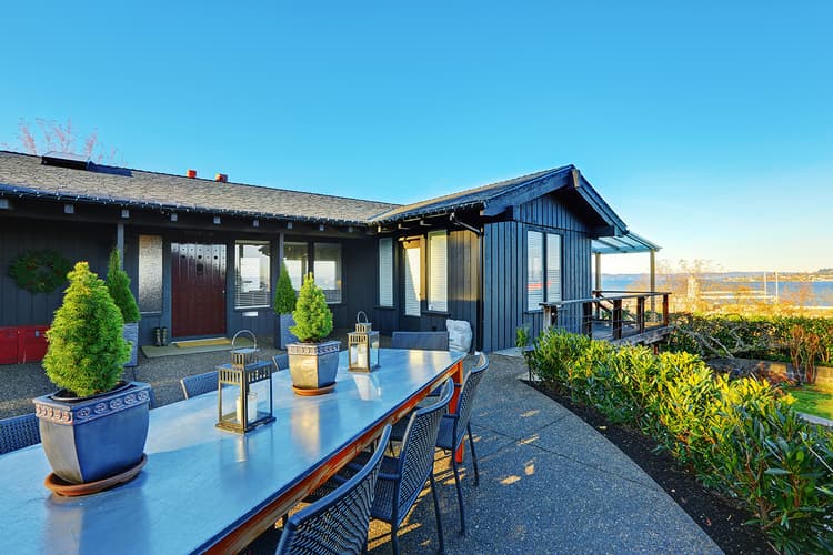 Waterfront house with table and chairs on patio Waterfront house with table and chairs on patio