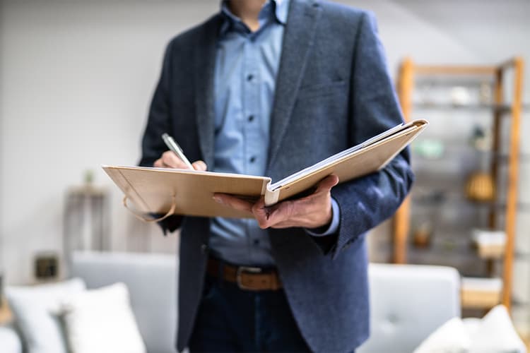 Appraiser in home writing in a notebook Appraiser in home writing in a notebook