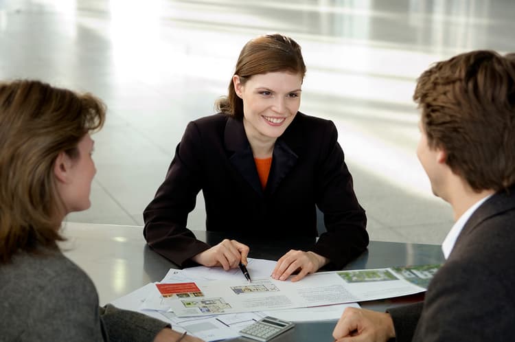 Real estate agent at table with clients Real estate agent at table with clients