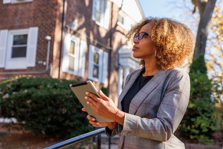 Real estate appraiser with clipboard outside a home Real estate appraiser with clipboard outside a home