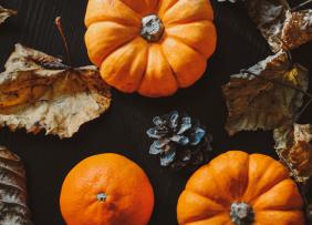 Pumpkins and fall leaves on a black table